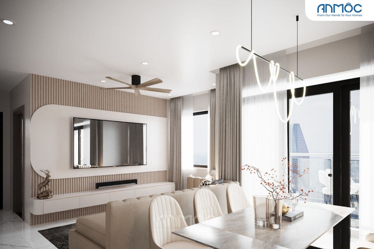 Khu vực phòng khách và ăn liền kề với sofa be, bàn ăn đá cẩm thạch, tủ TV ốp gỗ và đèn thả trần hình lượn sóng hiện đại