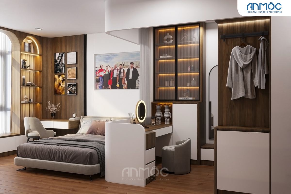 Toàn cảnh phòng ngủ nhìn từ cuối giường, hiển thị sự kết hợp giữa giường ngủ, bàn trang điểm, tủ quần áo và kệ trang trí âm tường tạo nên không gian ấm cúng.