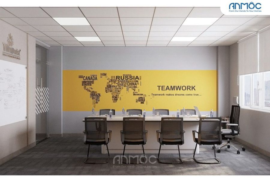Bàn họp nhìn từ góc, bức tường lớn trang trí bản đồ thế giới và chữ "TEAMWORK"