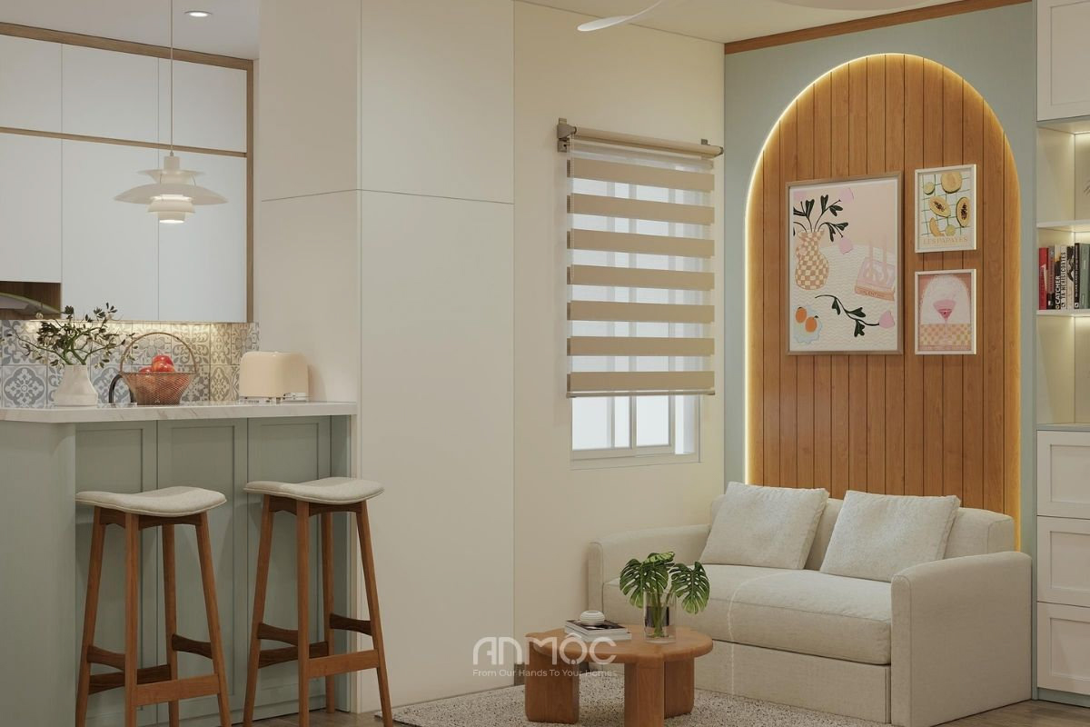 Phòng khách nhỏ với sofa màu be, bàn trà gỗ tròn và vách tường bo cong tạo điểm nhấn